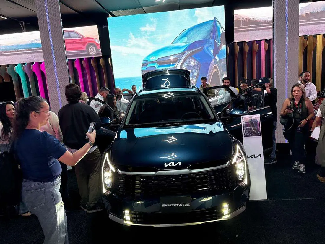 Visitantes frente a un Kia Sportage en el stand de la marca